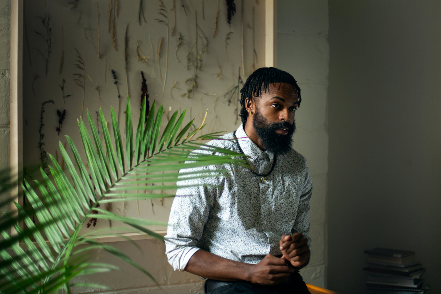bearded man in a room with a plant