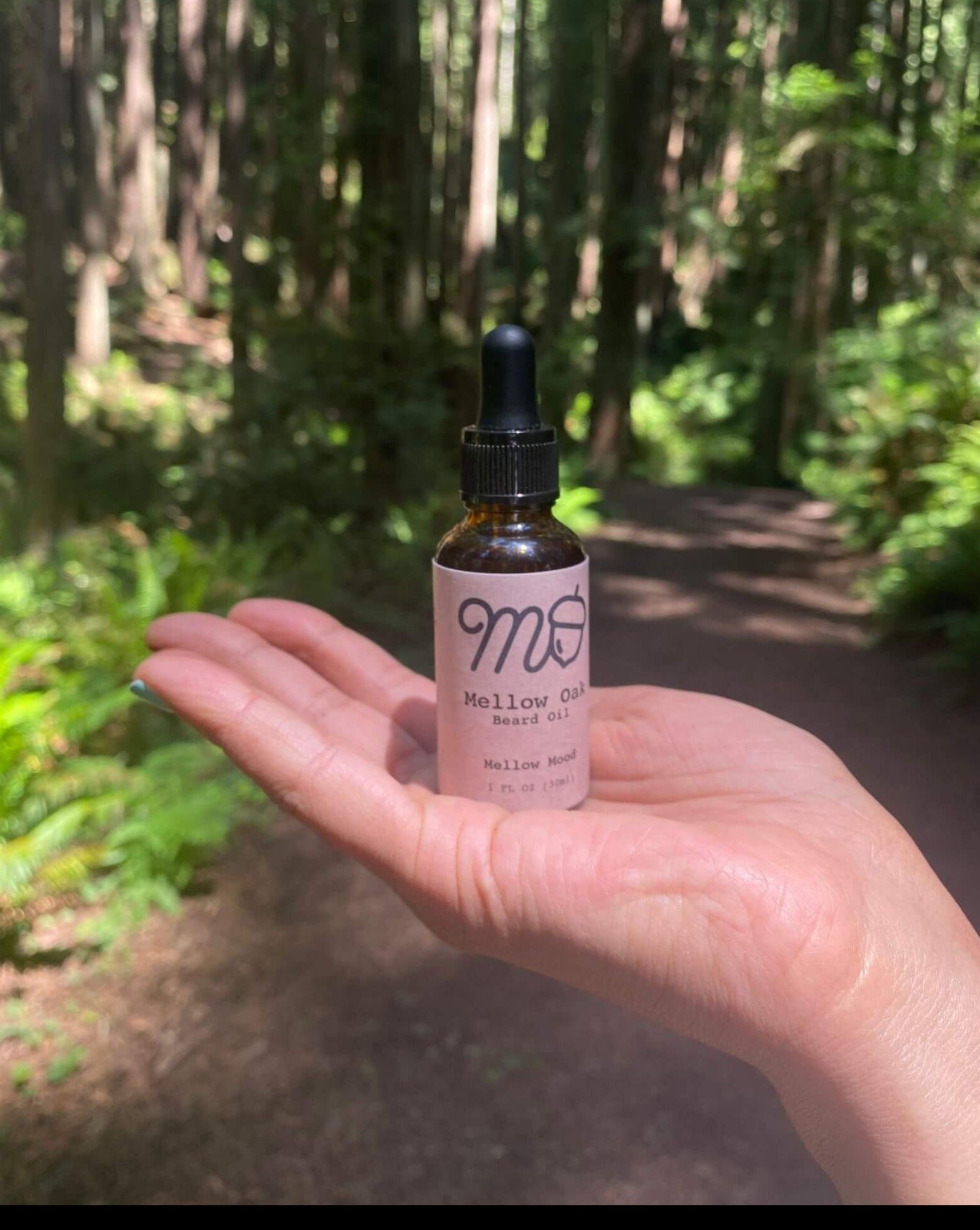 CBD Beard oil in woman's hand in the forest while hiking